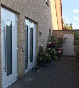 - un bâtiment en briques avec des portes et des fleurs sur une terrasse dans l'établissement Apartment Klatenberg, à Telgte