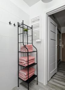 a towel rack in a bathroom with pink towels at Apartament Twoja Przystań in Jantar
