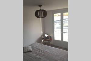 a bedroom with a bed and a window and a chair at L'esplanade in Saint-Jean-de-Monts