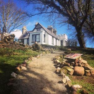 a house on a hill with a dirt road at The Valley House Hostel & Bar in Achill