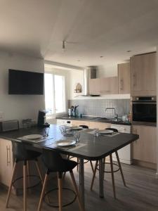 a kitchen with a table with chairs and a tableasteryasteryasteryasteryasteryastery at L'esplanade in Saint-Jean-de-Monts