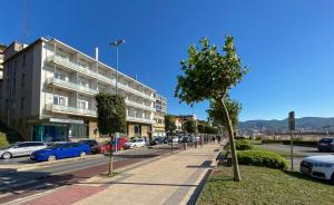 a street with cars parked in a parking lot at Petit Palace Tamarises in Getxo