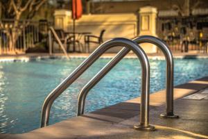 a swimming pool with metal hand rails next to a swimming pool at Hyatt Place Columbia/Harbison in Columbia