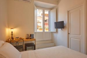 a bedroom with a bed and a desk and a window at Ripagrande a Trastevere in Rome