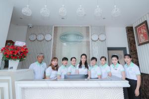 a group of people standing in front of a table at Phuc Hotel in Cao Lãnh