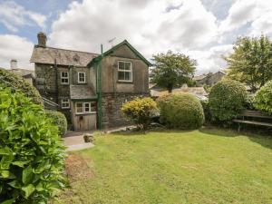 an old stone house with a grass yard at Anvil Cottage in Near Sawrey