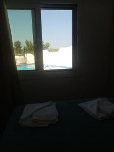 a room with a window with a view of a pool at Maria's Doll House in Adelianos Kampos