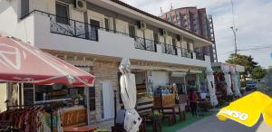 a building with a balcony with an umbrella and tables at Vila Marea Venusului in Venus