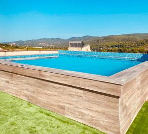 a large swimming pool with a retaining wall at Hotel Fonda Neus in Sant Sadurní dʼAnoia