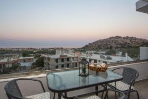 a table on a balcony with a view of a city at Kalathos Sea View House in Kalathos