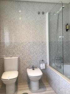 een badkamer met een toilet, een douche en een wastafel bij Complexo Alameda in Viveiro
