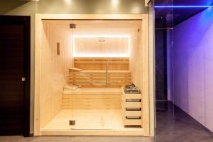 a large wooden sauna in a room with a purple light at Teseo Rooms & Relax in Genova