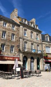 un gran edificio con mesas y sillas delante de él en Le Martray, en Paimpol