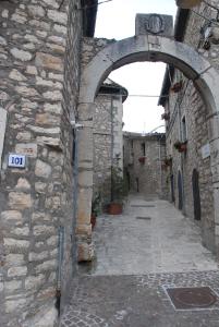 an alley with an archway in a stone building at Le case all'arco in Castropignano