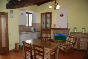 a kitchen with a wooden dining table and chairs at Le case all'arco in Castropignano