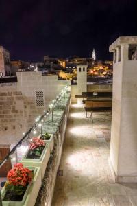 einen Balkon mit Blumen und Licht an einem Gebäude in der Unterkunft L'Artiere Dimore nei Sassi in Matera