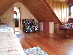 a attic room with a bed and a chair at Siedlisko Role in Role