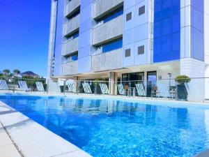 uma piscina em frente a um edifício em Alven Hotel by Slaviero Hotéis em Joinville