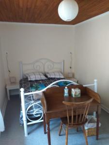 a bedroom with a bed with a desk and a table at Maison Belvoir in Le Fraysse