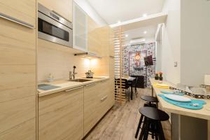 a kitchen with wooden cabinets and a counter with stools at Dimora San Gennaro 10 in Naples