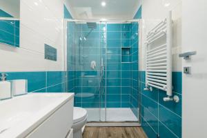 a blue tiled bathroom with a toilet and a shower at Dimora San Gennaro 10 in Naples +16 photos