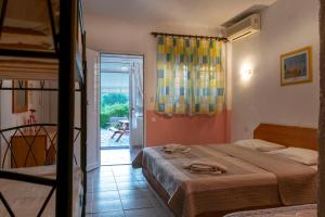 ネオス・マルマラスにあるVilla Gesthimaniのベッドルーム1室(ベッド1台付)、パティオへのドアが備わります。