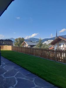 a wooden fence with green grass in a yard at Ferienwohnung 2 Haus Dörfler in Abtenau