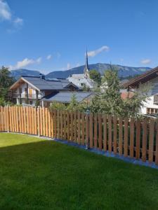 ein Holzzaun vor einem Hof mit grünem Gras in der Unterkunft Ferienwohnung 2 Haus Dörfler in Abtenau