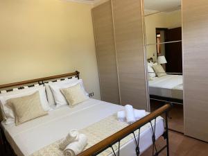 een slaapkamer met een bed en een spiegel bij Seaside "Stone & Light Villa" close to Aegina City in Khlóï