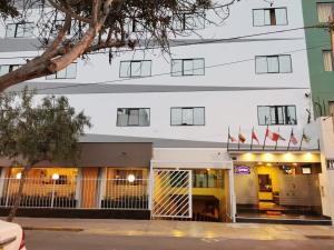 a building with flags in front of it at Hotel Dia y Noche in Lima
