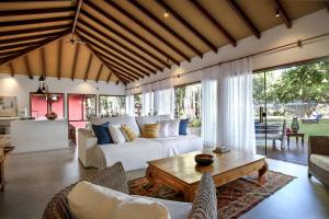 a living room with a white couch and a table at Natura Spa Guest House in Arraial D'Ajuda in Arraial d'Ajuda