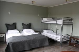 South Iceland Guesthouse في Steinar: غرفة نوم بسريرين بطابقين مع ملاءات بيضاء