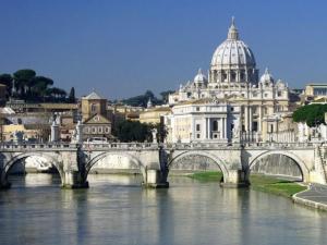 a bridge over a river in front of a city at LE FATE SUITES in Rome