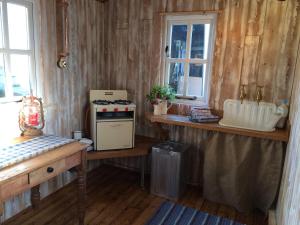 a kitchen with wooden walls and a counter with a stove at Black Mountain BreakAway in Llangadog