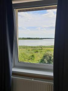 a window with a view of a body of water at Arielle in Łazy