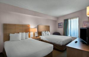 ein Hotelzimmer mit zwei Betten und einem Flachbildfernseher in der Unterkunft Sea Watch Resort in Myrtle Beach + 44 Fotos