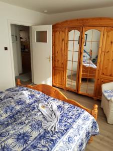 a bedroom with a bed with a blue and white bedspread at Ferienwohnung Hummer im Haus Daheim in Helgoland
