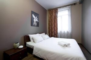a bedroom with a large white bed with a window at Aparthotel Na Mytniy in Lviv