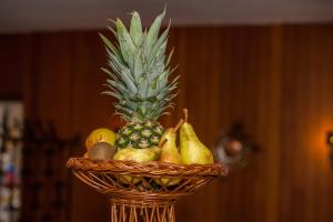 a basket of fruit with a pineapple and pears at Genussgasthof Fuldaquelle & Berghof Wasserkuppe in Gersfeld