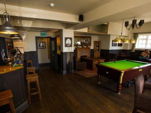 a pub with a pool table in the middle of a room at The George in West Bay