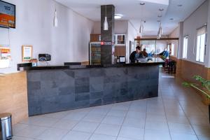 a bar in a restaurant with people sitting at tables at Hotel Ipiranga Maringa in Maringá