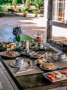 uma mesa coberta com pratos de comida numa mesa em Pousada La Vista em Gramado