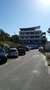 een parkeerplaats met auto's voor een gebouw bij Appartement Mimizan Plage accès direct plage surveillée in Mimizan