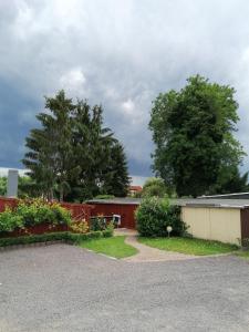 een huis met een hek en bomen op de achtergrond bij Ferienwohnung Am Atelier in Rathenow