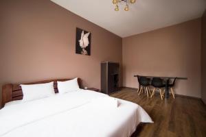 una camera con letto, tavolo e sedie di Aparthotel Na Mytniy a Lviv