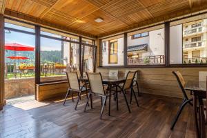 a dining room with tables and chairs and windows at Amarena SPA Hotel - Breakfast included in the price Spa Swimming pool Sauna Hammam Jacuzzi Restaurant inexpensive and delicious food Parking area Barbecue 400 m to Bukovel Lift 1 room and cottages in Bukovel