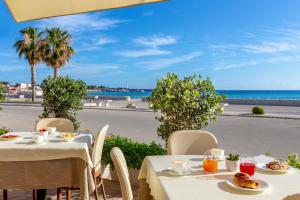 a table with food and a view of the ocean at Mira Spiaggia in San Vito lo Capo