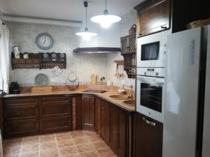 a kitchen with wooden cabinets and a white refrigerator at Casa Candela in Ronda