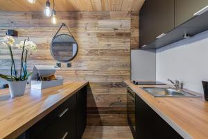 - une cuisine avec un comptoir et un mur en bois dans l'établissement Appartement de charme hyper centre à Val d'Isère, à Val dʼIsère