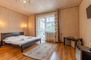 a bedroom with a bed and a large window at Hotel Pid Strihoju in Bukovel